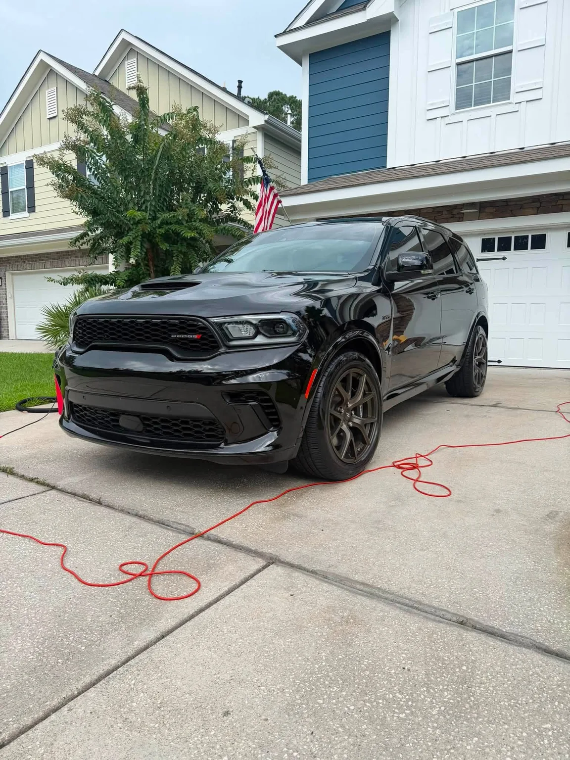 Black Dodge SUV cleaned on a residential driveway